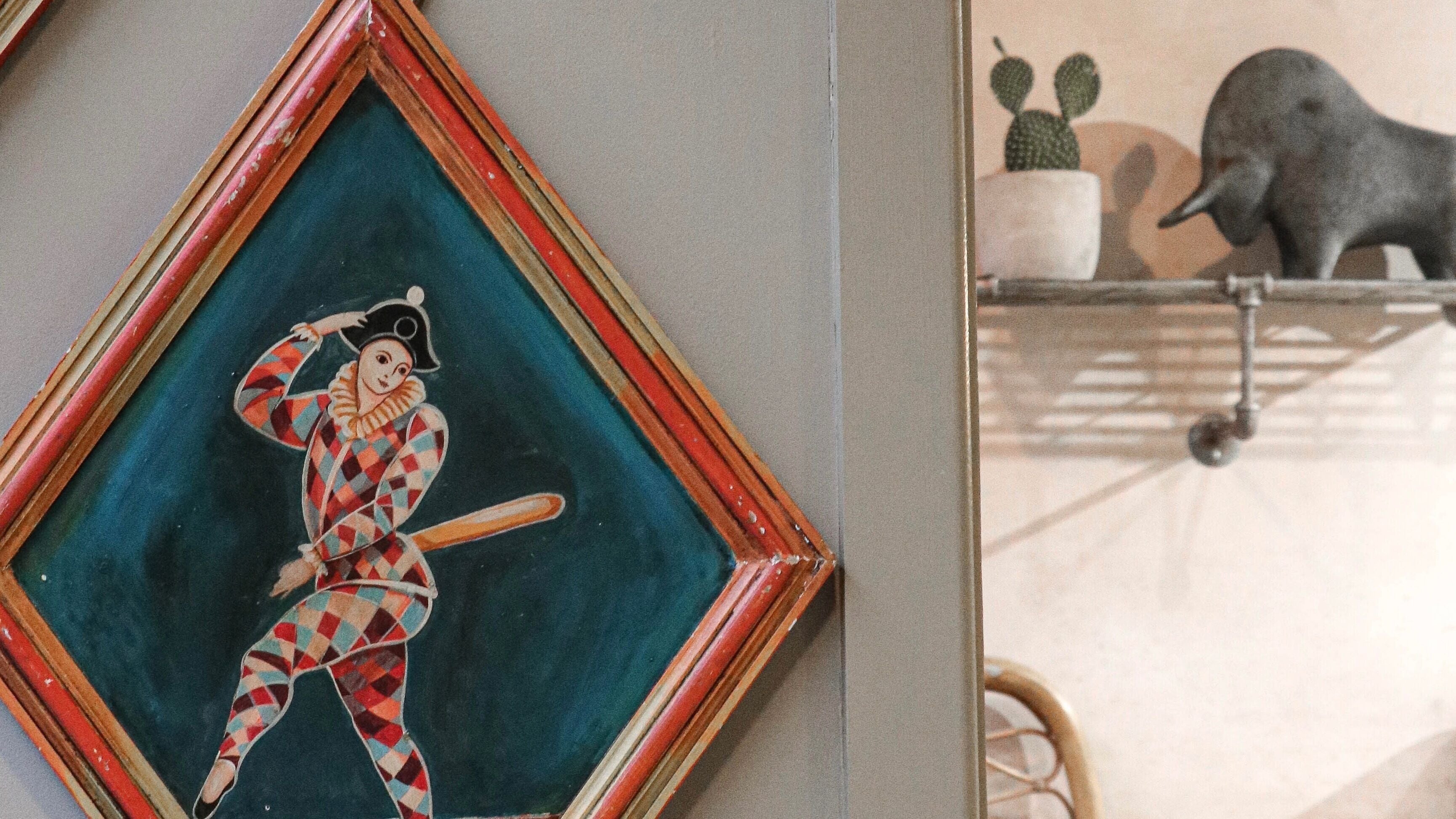 Artistic wall decor at Cuttlefish Eco Salon - Lewes, featuring a colorful harlequin painting, Lewes, England, GB.