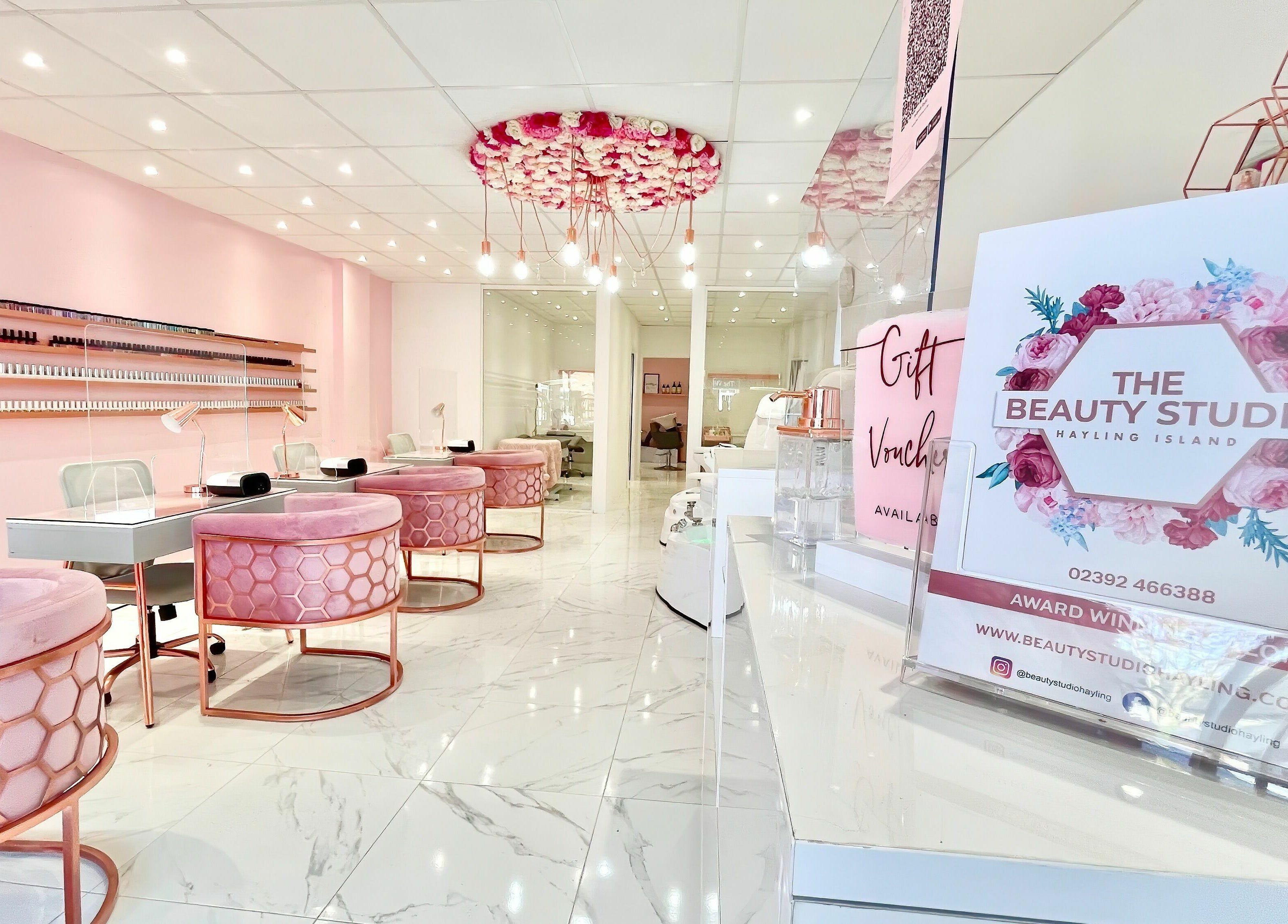 Elegant interior of The Beauty Studio, Hayling Island, England, with chic pink decor and manicure stations.