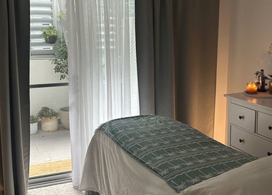 Cozy treatment room at Society Isle Beauty and Wellbeing in Bulimba, Queensland, AU, with ambient lighting.