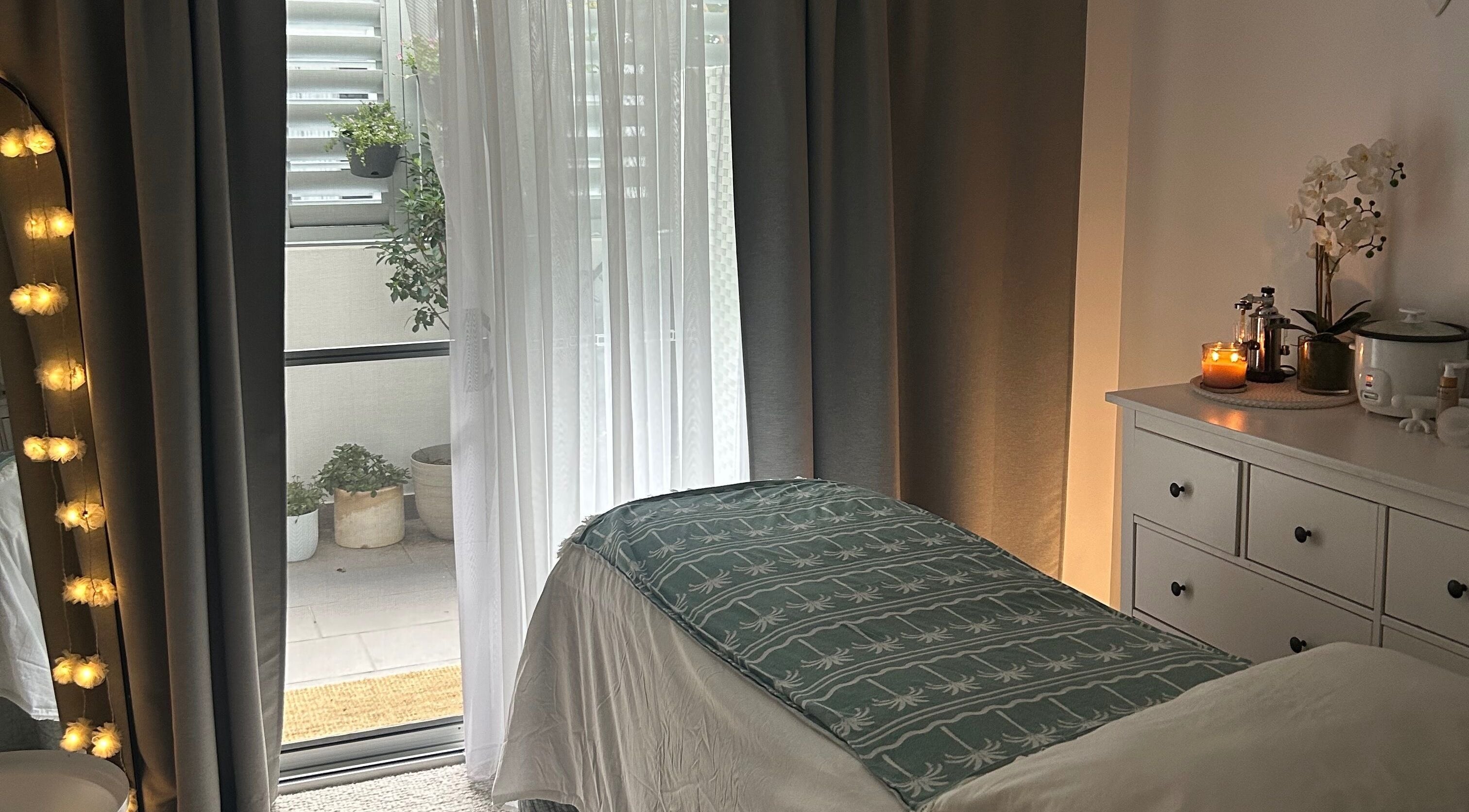 Cozy treatment room at Society Isle Beauty and Wellbeing in Bulimba, Queensland, AU, with ambient lighting.