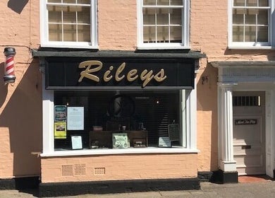Exterior of Rileys Barbers in Manningtree, England, GB, showcasing a classic barber pole and inviting entrance.