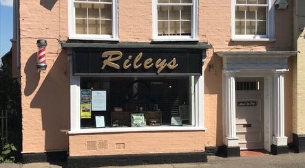 Exterior of Rileys Barbers in Manningtree, England, GB, showcasing a classic barber pole and inviting entrance.