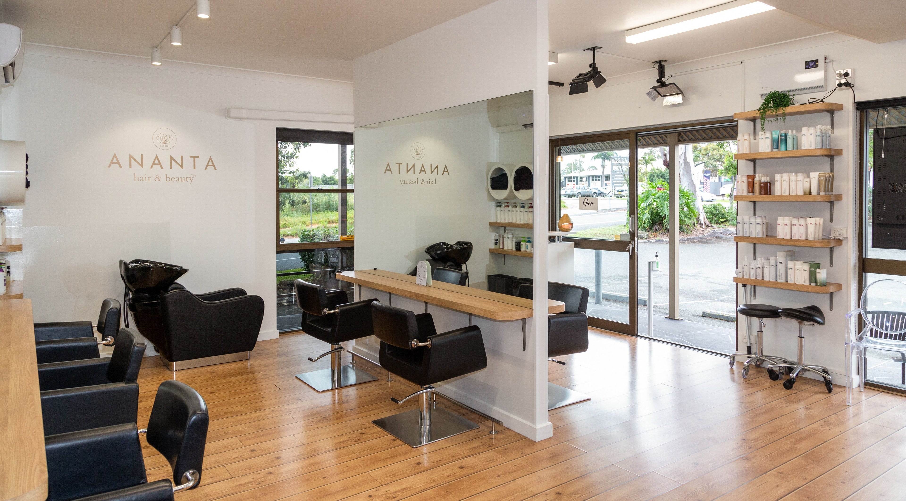 Modern interior of Ananta Hair & Beauty in Oxenford, Queensland, AU, featuring sleek styling chairs and products.