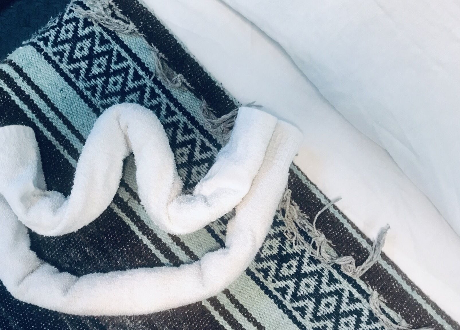 White towel elegantly folded on patterned linen at Motif Medi Spa, Nassau, New Providence, BS.