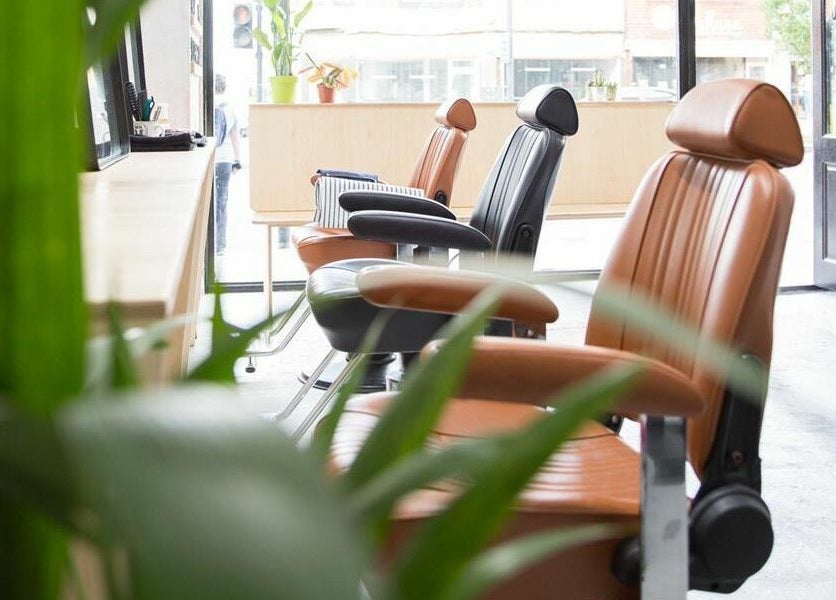 Modern salon chairs at Off Cut Streatham, a stylish beauty venue in London, England, GB, surrounded by plants.