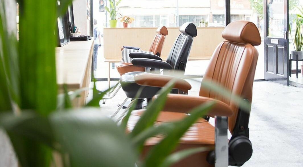 Modern salon chairs at Off Cut Streatham, a stylish beauty venue in London, England, GB, surrounded by plants.