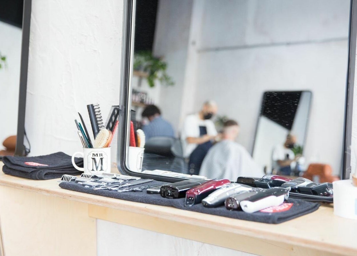 Hairdressing tools at Off Cut Streatham, London, England, GB with stylist working in background.
