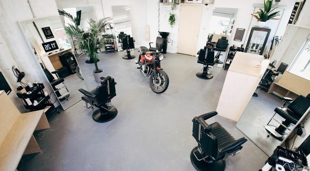 Stylish interior of Off Cut, Crystal Palace, London, England, GB, featuring sleek barber chairs and plants.