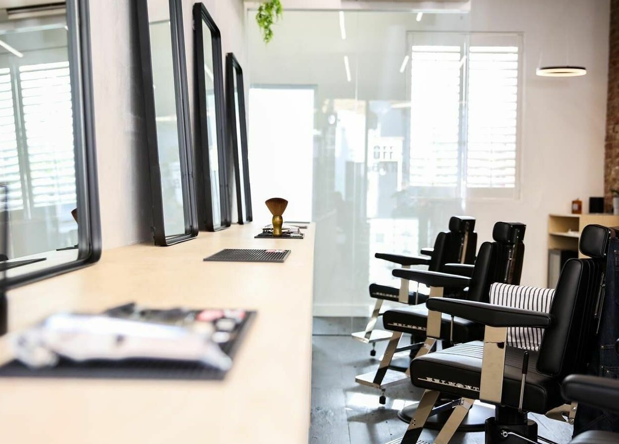 Modern barber chairs at Off Cut, Crystal Palace, London, England, GB enhance the salon's elegant atmosphere.