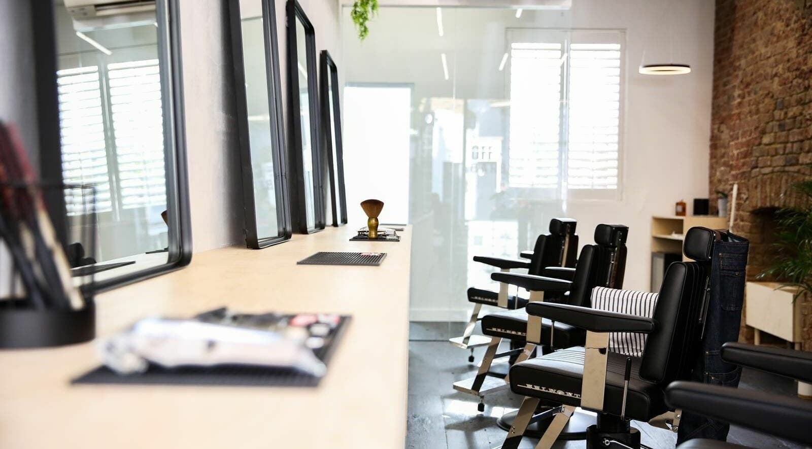 Modern barber chairs at Off Cut, Crystal Palace, London, England, GB enhance the salon's elegant atmosphere.