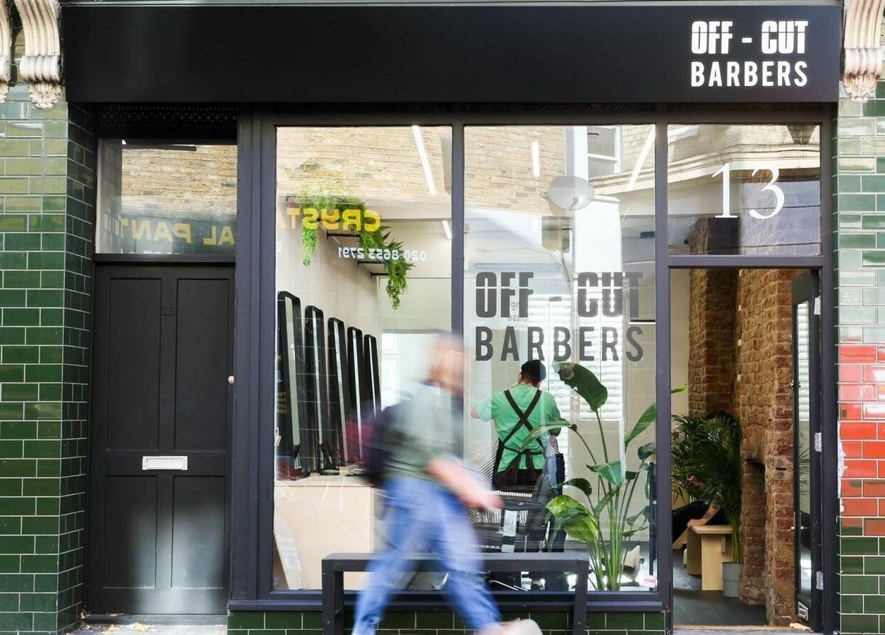 Off Cut, Crystal Palace barbershop exterior in London, England, GB with green tiles and stylish signage.