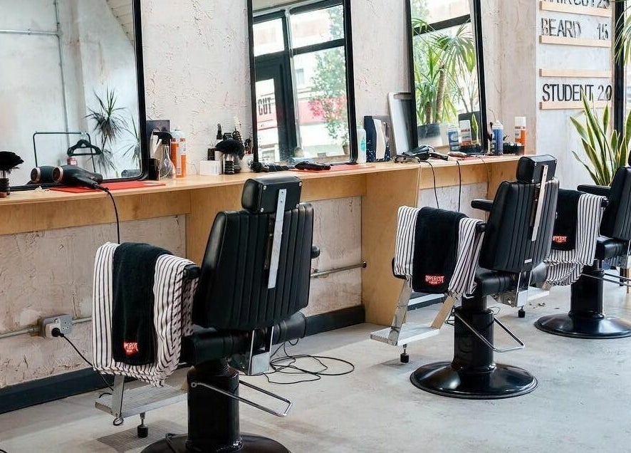 Modern barber chairs and mirrors at Off Cut, Peckham in London, England, GB showcasing a sleek interior.