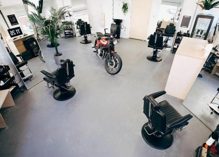 Chic interior of Off Cut, Peckham salon in London, England, GB featuring black chairs and mirrors.