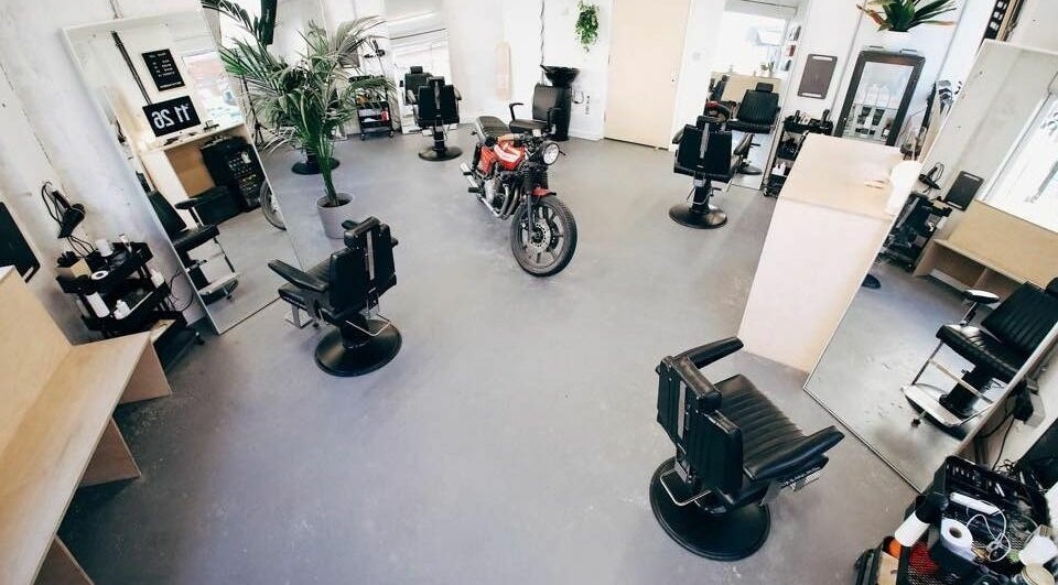 Chic interior of Off Cut, Peckham salon in London, England, GB featuring black chairs and mirrors.