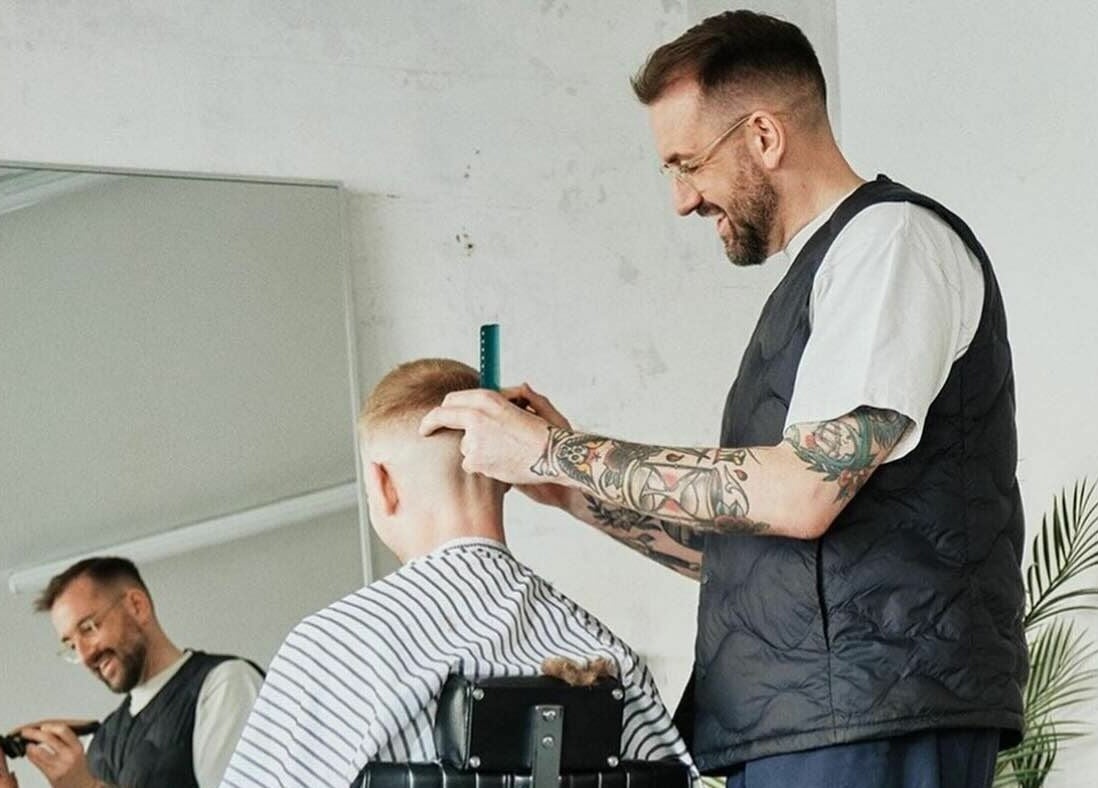 Barber giving a haircut at Off Cut, Peckham in London, England, GB. Modern and trendy salon experience.