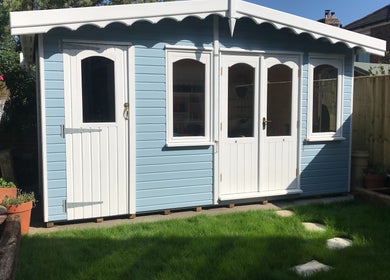 Charming outdoor studio at The Kids Hair Studio, Ryde, GB, surrounded by greenery and vibrant pots.