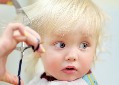 Child receiving a haircut at The Kids Hair Studio, Ryde, GB.