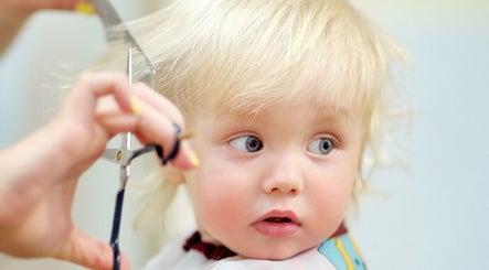 Child receiving a haircut at The Kids Hair Studio, Ryde, GB.