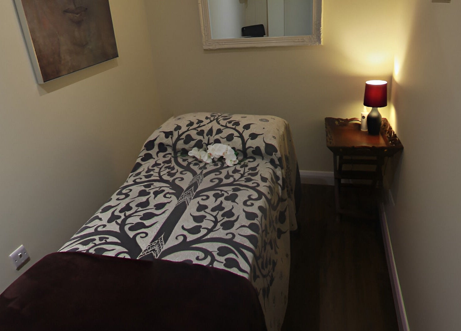 Tranquil massage room at Natural Body Cafe, Poole, England with decorative linens and soft lighting.