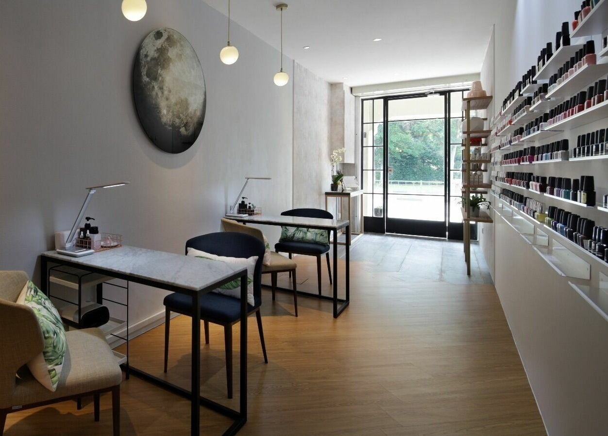 Modern interior of Painted Nail Bar at River Valley, Singapore, with nail polish displays and seating.