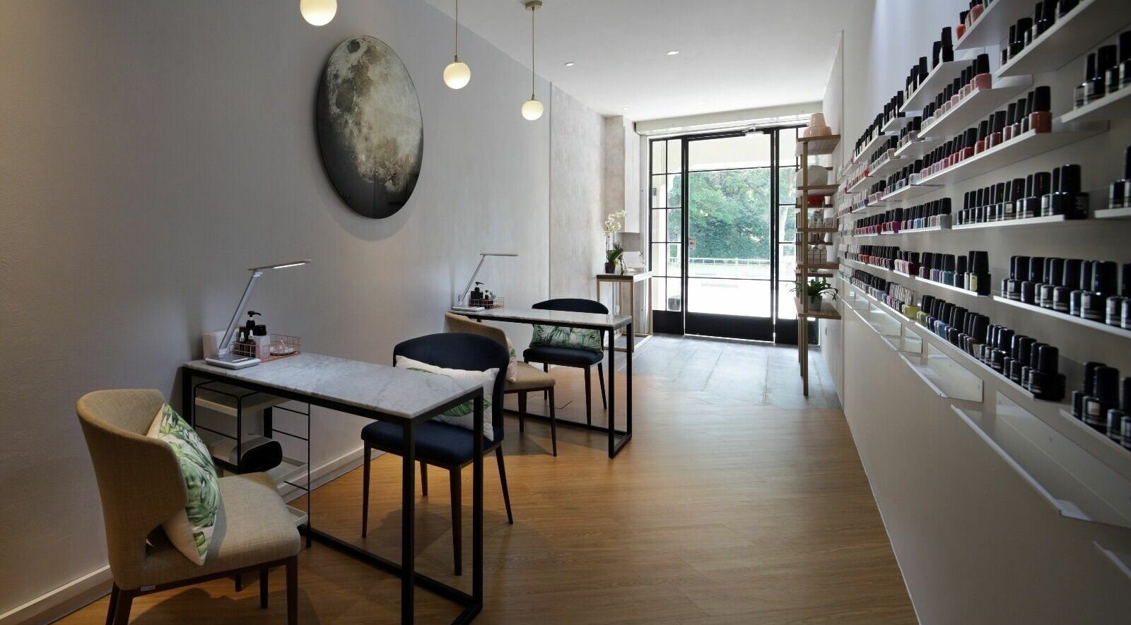 Modern interior of Painted Nail Bar at River Valley, Singapore, with nail polish displays and seating.