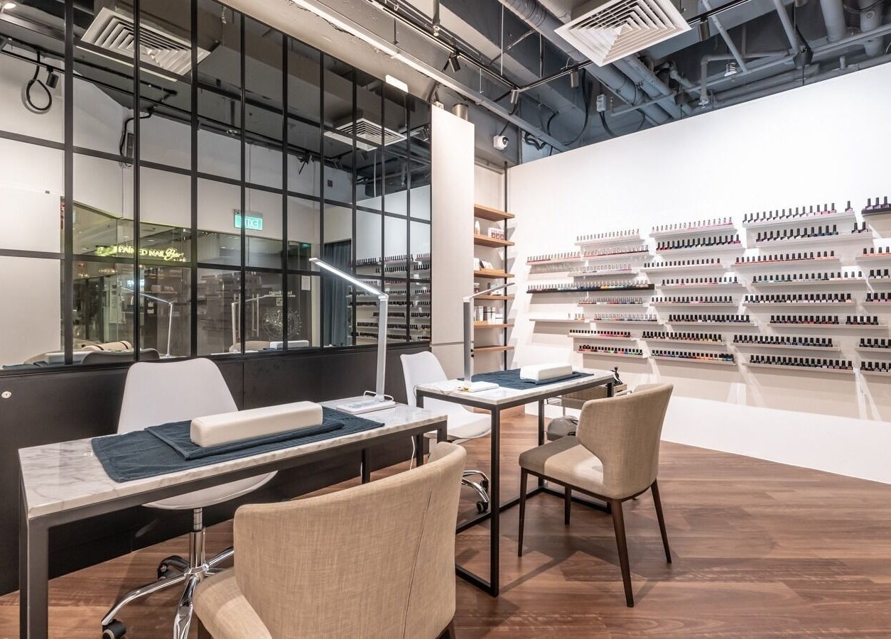 Modern interior of Painted Nail Bar at Delfi Orchard, Orchard Road, Singapore, SG, featuring elegant nail tables.