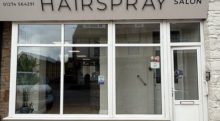 Front view of Hairspray salon with glass windows in Bingley, England, GB.