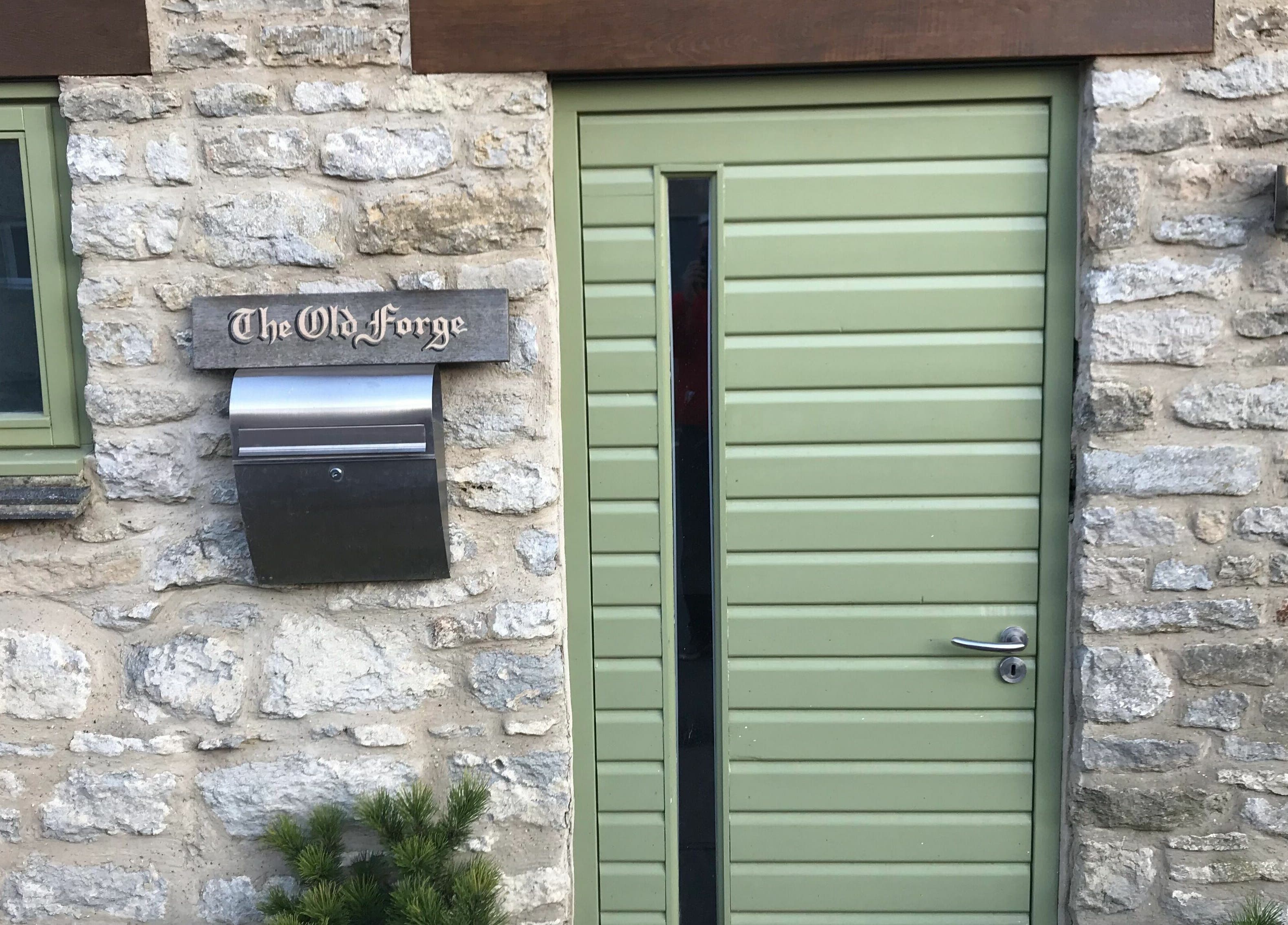 Charming stone facade with green door at Pure Indulgence Day Spa, Merton, England, GB.
