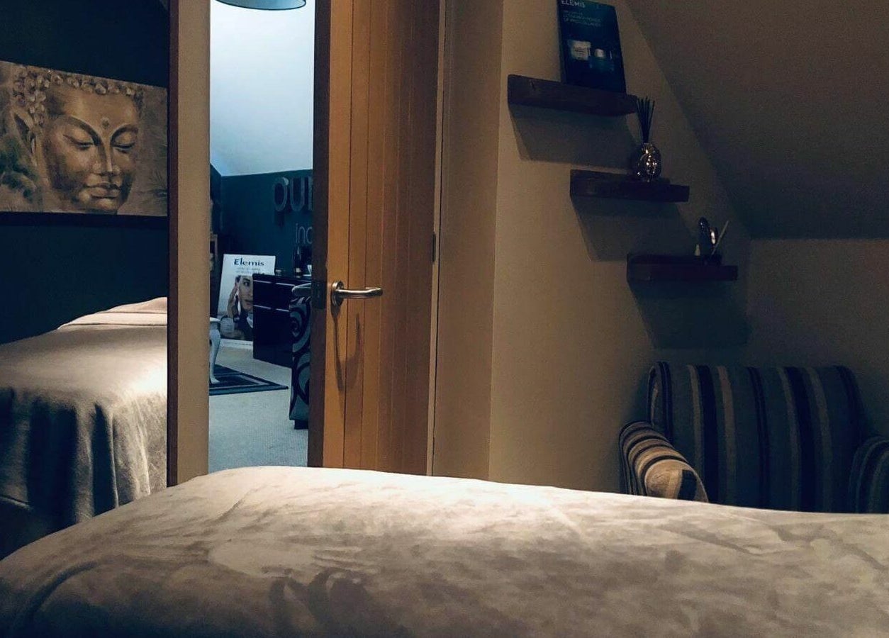 Cozy treatment room at Pure Indulgence Day Spa in Merton, England, GB with calming Buddha artwork.