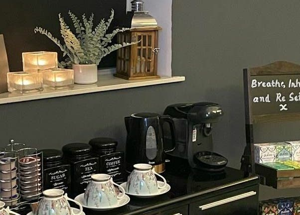 Relaxing tea and coffee corner at Pure Indulgence Day Spa, Merton, England, GB, with candles and soothing decor.