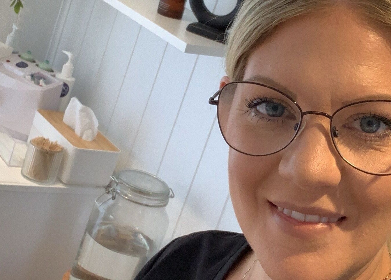 Interior at The Beauty Hut, Wivelsfield Green, England, featuring salon essentials and a smiling staff member.