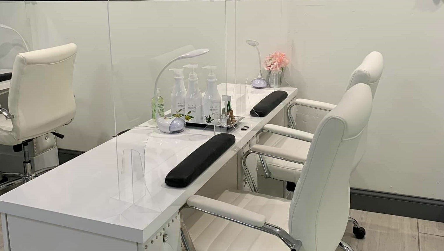 Sleek nail care station at Dashing Diva Nails and Spa, Swampscott, Massachusetts, US, featuring white chairs.