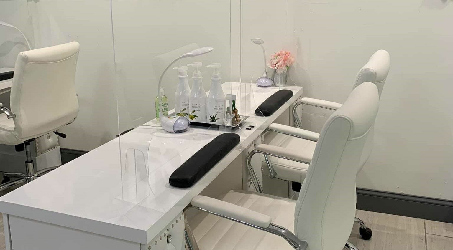 Sleek nail care station at Dashing Diva Nails and Spa, Swampscott, Massachusetts, US, featuring white chairs.