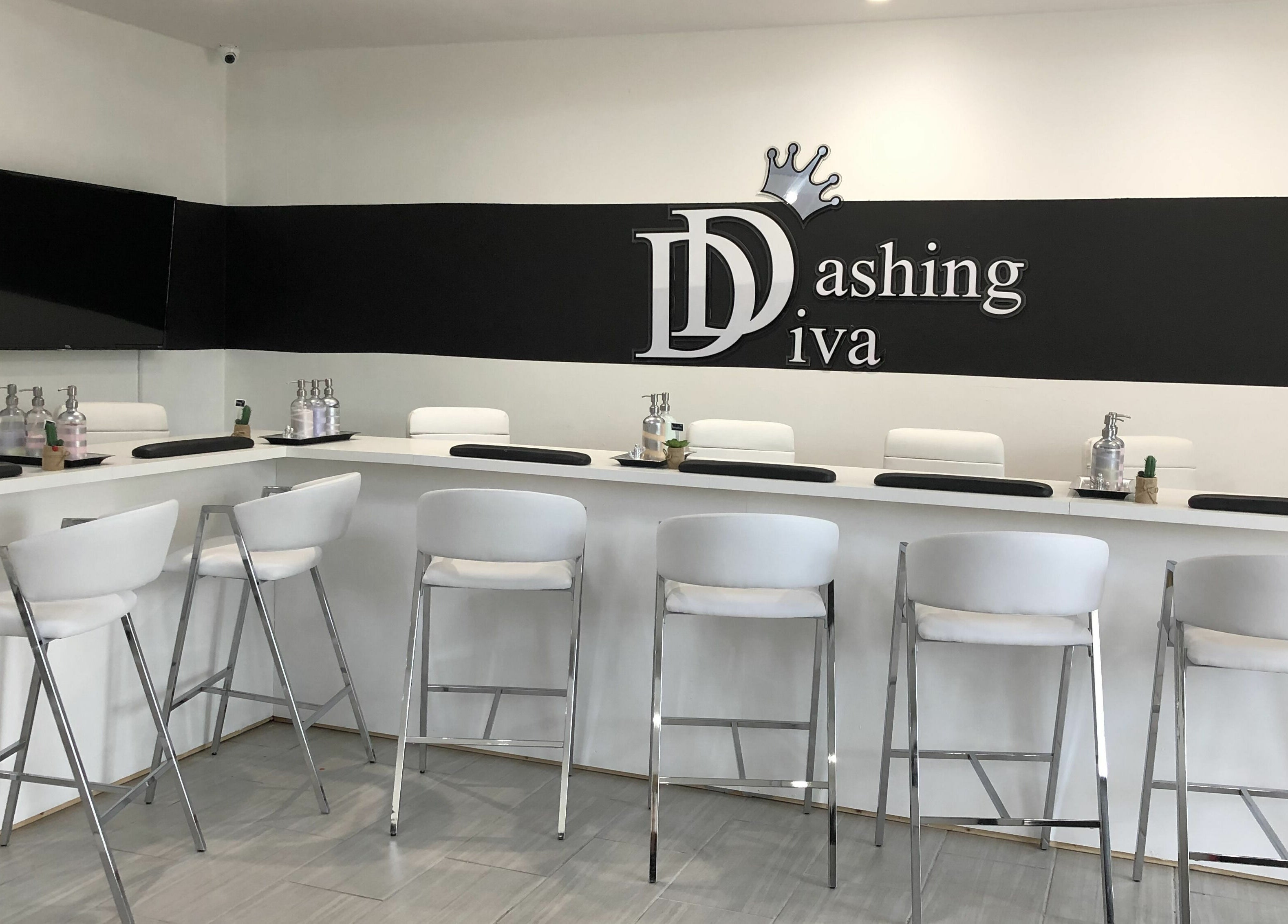 Modern nail bar at Dashing Diva Nails and Spa, Swampscott, Massachusetts, US, featuring sleek white seating.