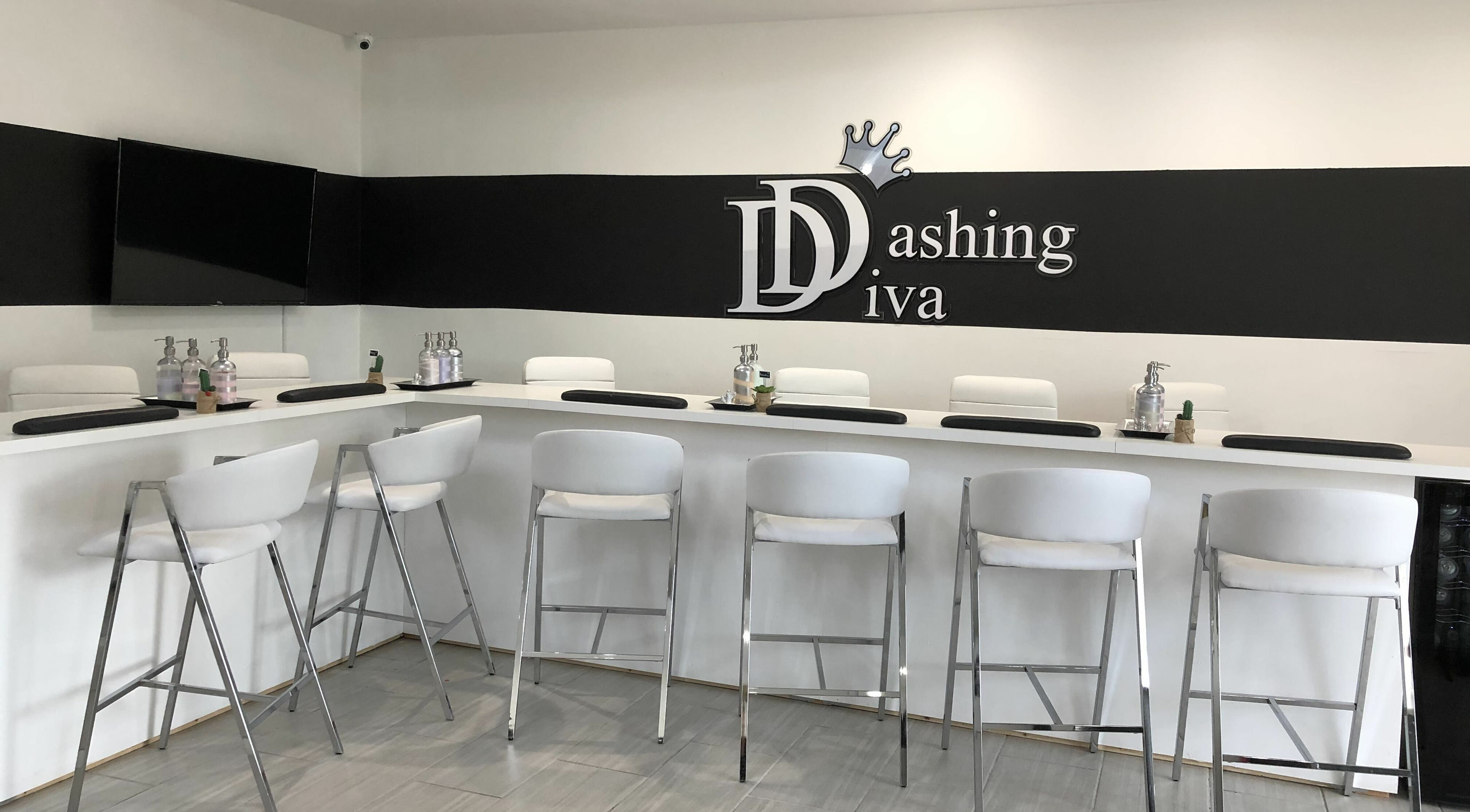 Modern nail bar at Dashing Diva Nails and Spa, Swampscott, Massachusetts, US, featuring sleek white seating.