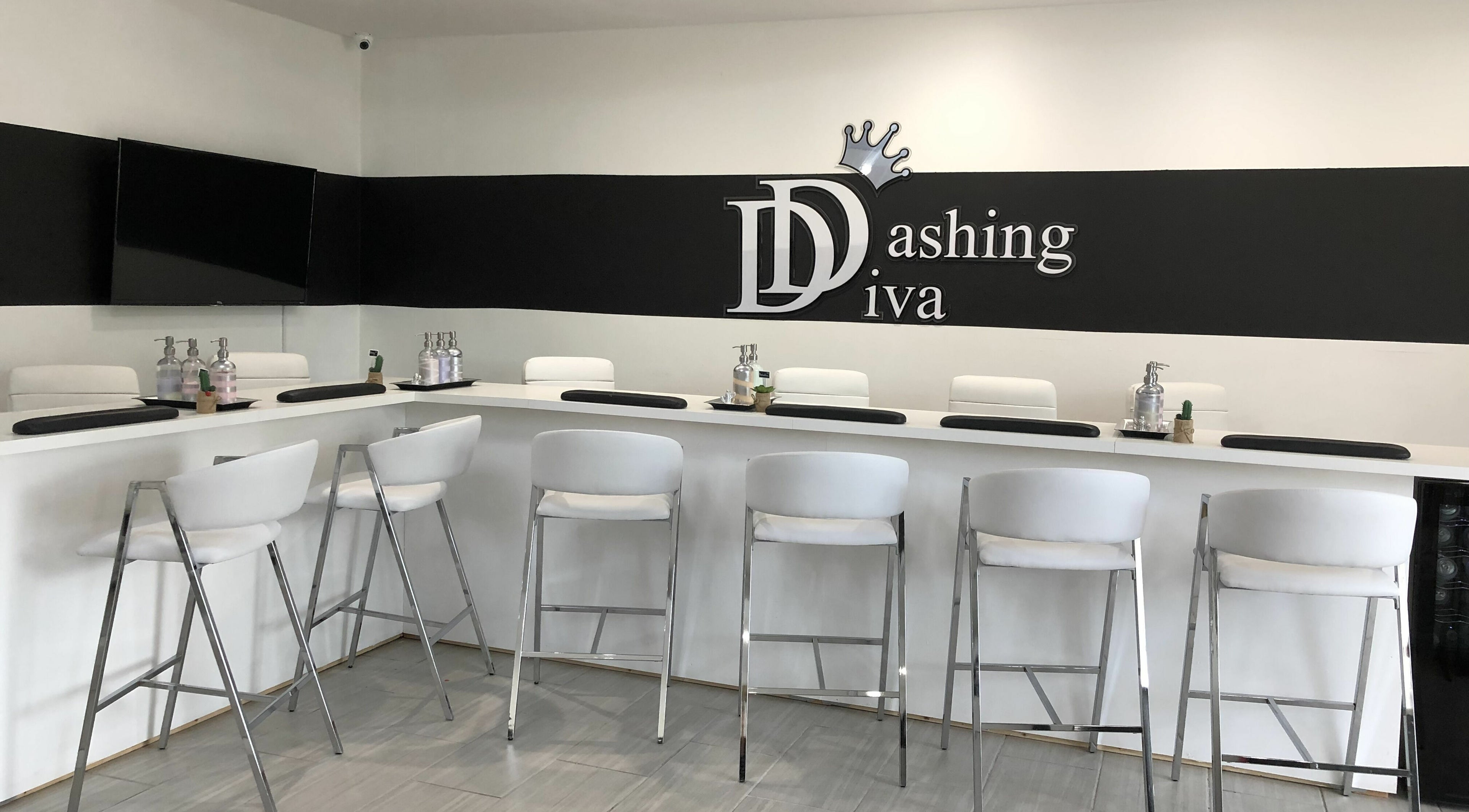 Modern nail bar at Dashing Diva Nails and Spa, Swampscott, Massachusetts, US, featuring sleek white seating.