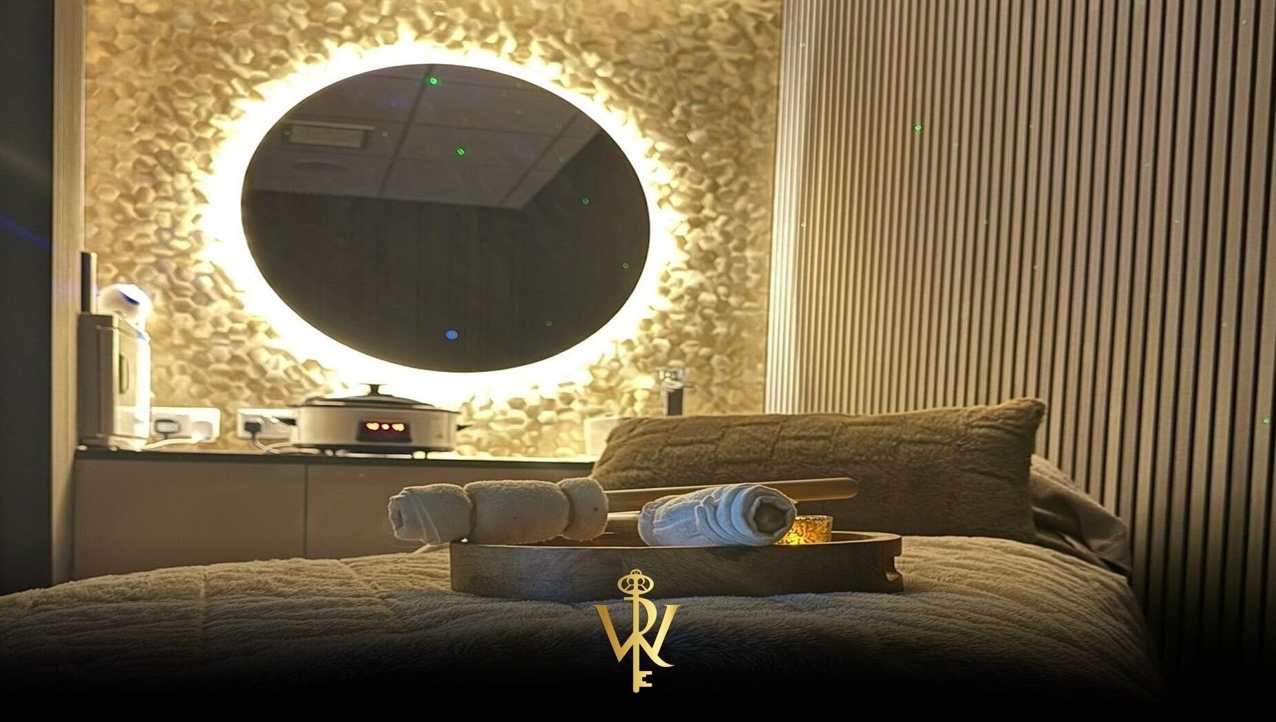 Relaxing spa room at Revive the Key to Wellness, Scotland, GB with glowing mirror and soft linens.