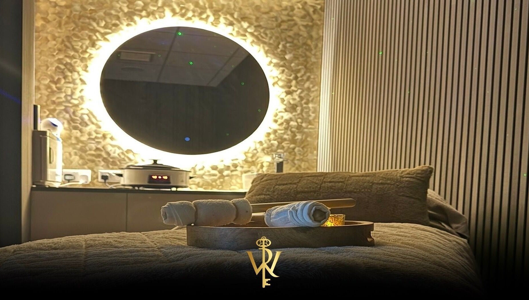 Relaxing spa room at Revive the Key to Wellness, Scotland, GB with glowing mirror and soft linens.