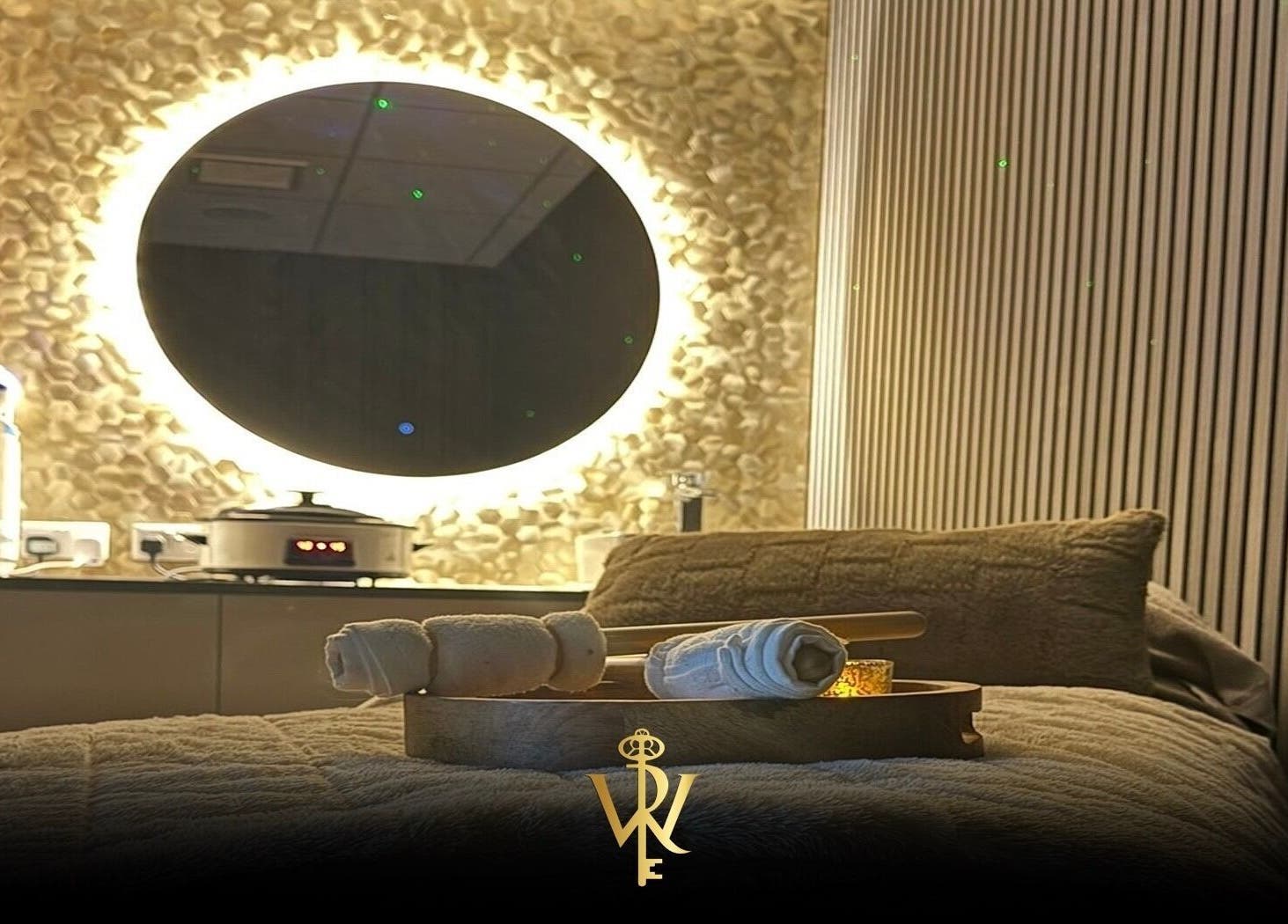 Relaxing spa room at Revive the Key to Wellness, Scotland, GB with glowing mirror and soft linens.