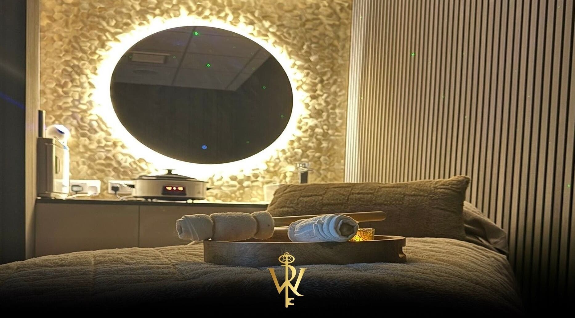 Relaxing spa room at Revive the Key to Wellness, Scotland, GB with glowing mirror and soft linens.