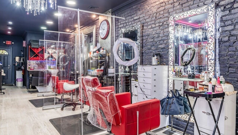 Stylish interior of Brooklyn Beauty Lounge in New York, US showcasing red chairs and ornate mirrors.