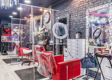 Stylish interior of Brooklyn Beauty Lounge in New York, US showcasing red chairs and ornate mirrors.