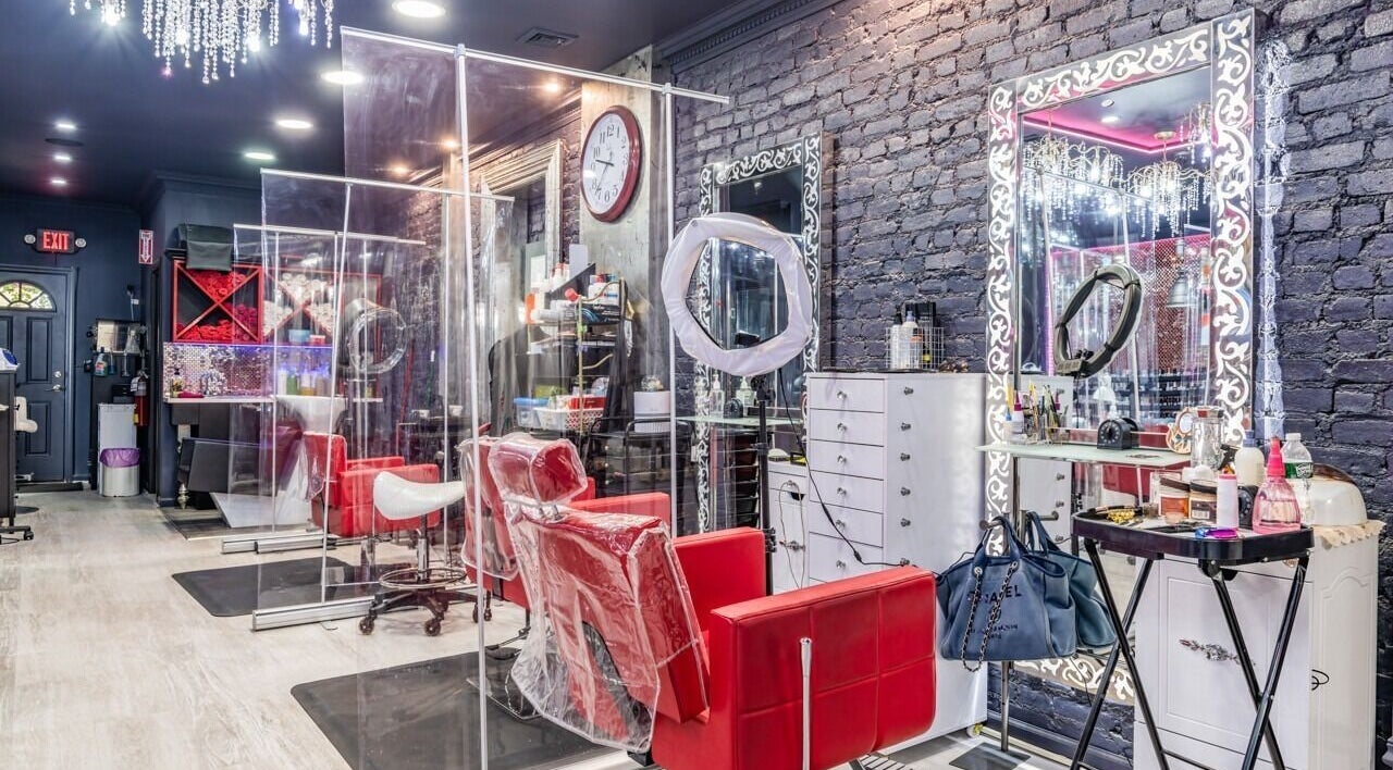 Stylish interior of Brooklyn Beauty Lounge in New York, US showcasing red chairs and ornate mirrors.