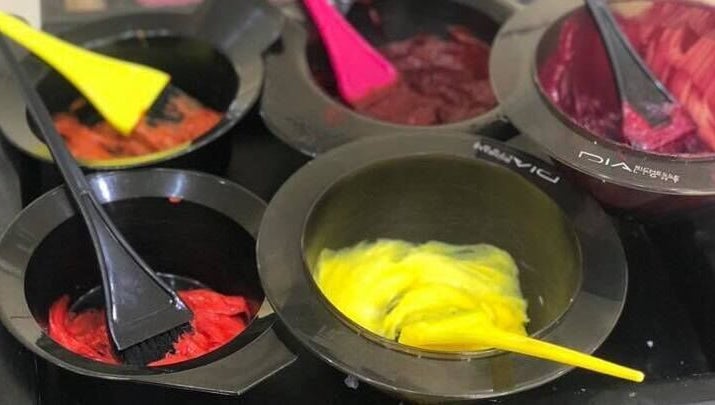 Bright hair dye bowls at Headquarters Salon in Reading, England, GB, showcasing vibrant color options.