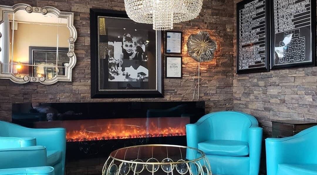 Chic lounge area at Charity's Essentials Ageless Spa, Yuma, ARIZONA, US. Features turquoise chairs and a cozy fireplace.