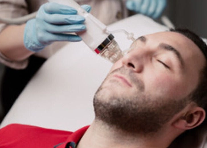 Man receiving a facial treatment at Esthinity, a premier wellness venue in Glasgow, Scotland, GB.