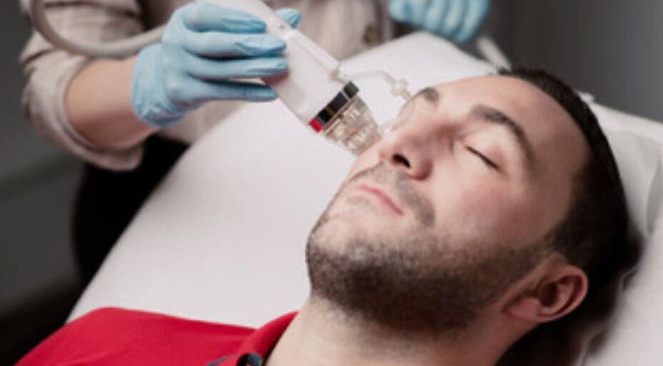 Man receiving a facial treatment at Esthinity, a premier wellness venue in Glasgow, Scotland, GB.