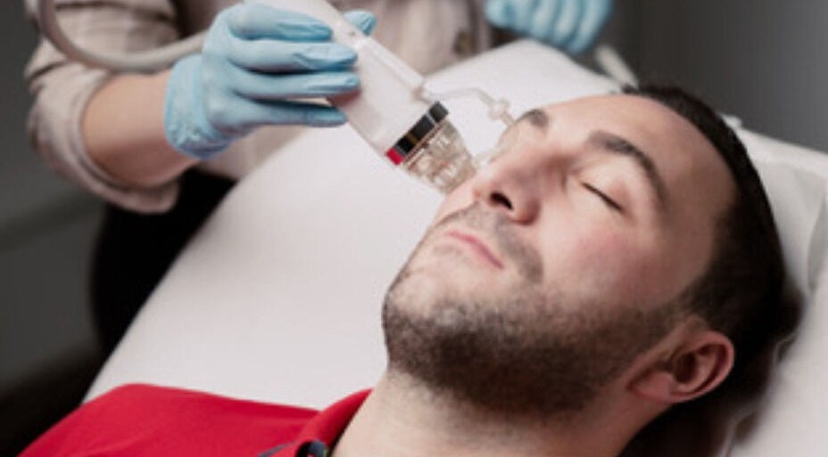 Man receiving a facial treatment at Esthinity, a premier wellness venue in Glasgow, Scotland, GB.