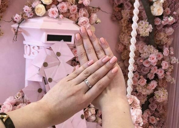 Manicured hands in front of floral decor at Nail'd It London, Glendale, California, US.
