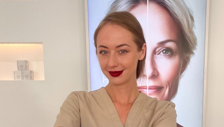 Professional at Skin Aesthetic in Trowbridge, England, GB, standing confidently in front of a beauty poster.